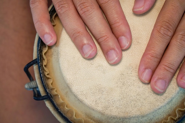 Closeup of fingers play the african drumaerial view music\
therapy with percussion workshop