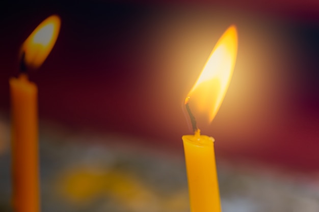 Closeup fire at candle burning in Thailand Temple traditional Thai Buddhist worship.