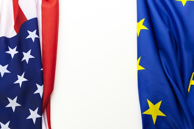 テーブルの上に一緒に横になっている米国および欧州連合の旗のクローズアップ