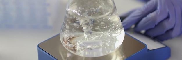 Foto primo piano del pallone con liquido bollente sul riscaldatore negli esperimenti chimici del laboratorio di ricerca e