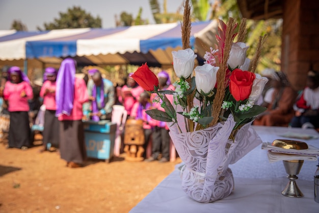 Closeup of the flowers placed on the priest39s table during mass in africa the nuns in the blurry background sing during at the celebration