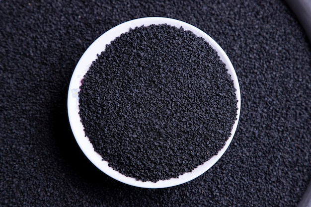 Крупный план фокусирует вид сверху на семена черного лука в миске из белой керамики