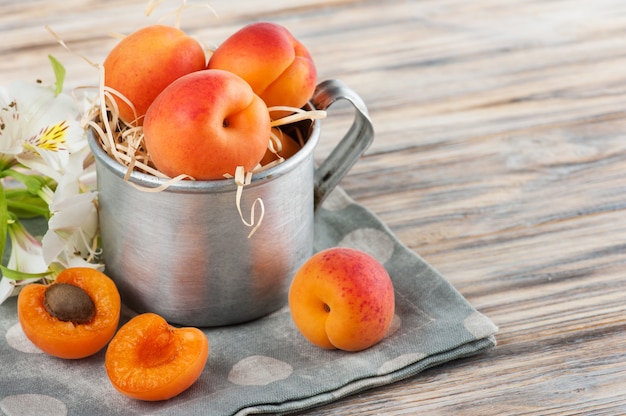 Closeup of fresh apricots in tin mug