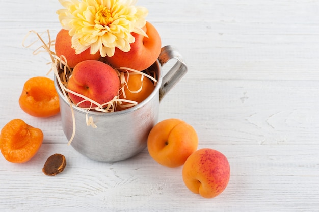 Closeup of fresh apricots in tin mug