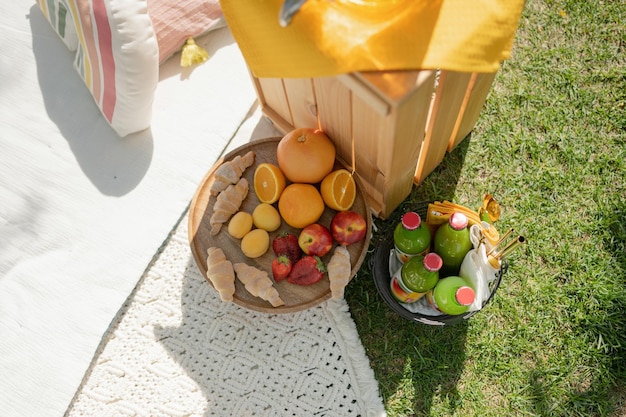 公園でのピクニックのバスケットに入った新鮮な果物とジュースのクローズアップ