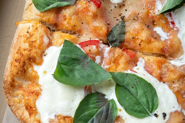 Primo piano della pizza romana calda fresca con le erbe e il fuoco selettivo macrophoto del fast food della pizza italiana del cibo