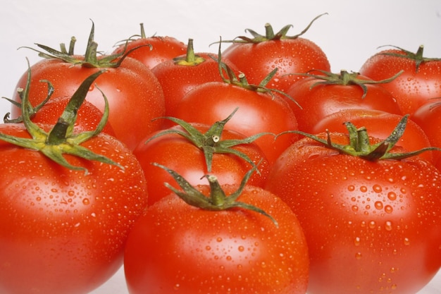 Closeup of fresh and juicy tomatoes covered with water drops