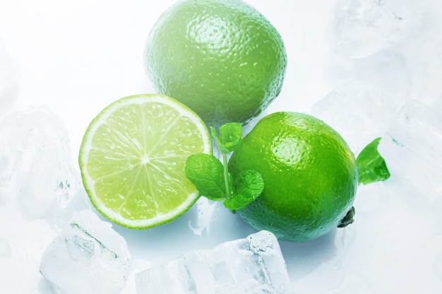 Closeup of fresh lime fruits with mint and ice cubes