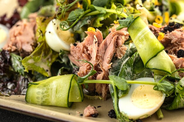 Closeup on fresh tuna salad with greens and eggs