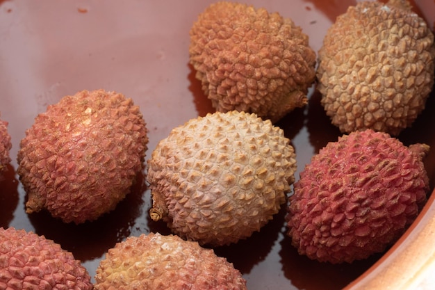 Closeup of fresh whole ripe lychee fruits in a ceramic bowl