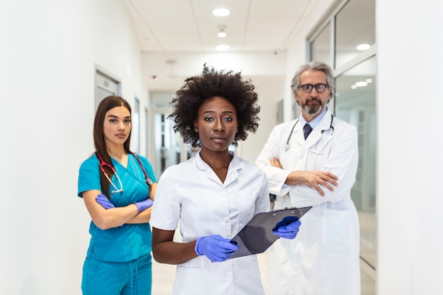 Closeup front view of group of mixed age doctors and nurses standing side by side and looking at the camera.