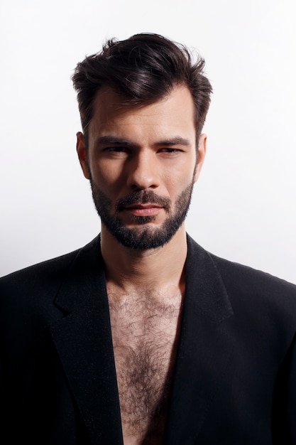 Closeup frontal  bearded man posing in black suit, with naked torso