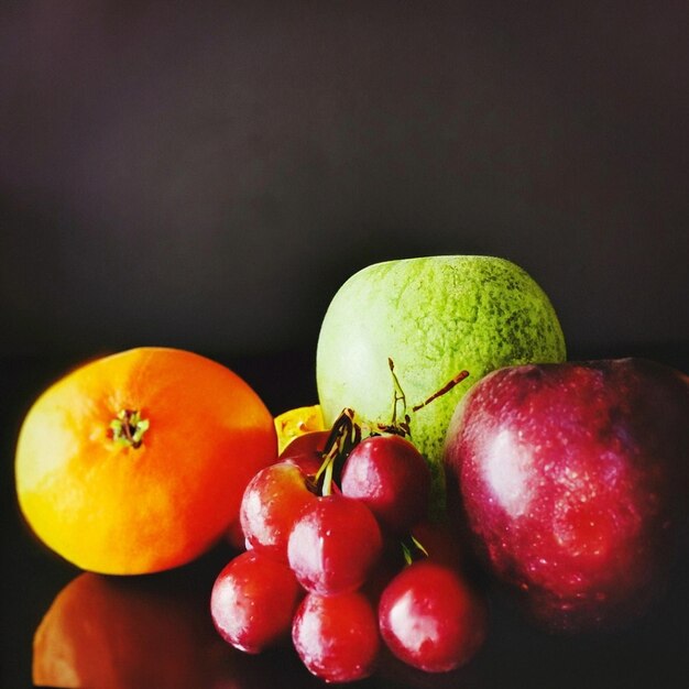 Photo closeup of fruits on table against black background