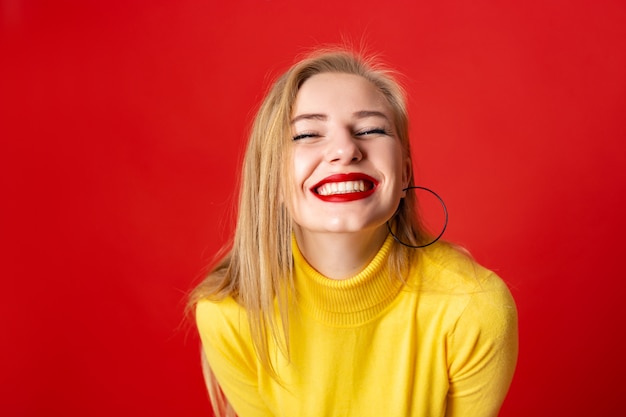 Il fronte della ragazza di divertimento del primo piano che ride esaminando la macchina fotografica - ampio sorriso