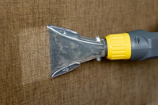 Closeup of a furniture vacuum cleaner and a dirty sofa Cleaning and house cleaning housekeeper