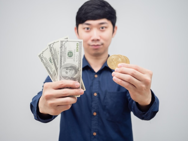 Closeup geld en gouden bitcoin in Aziatische man glimlach gezicht op witte achtergrond digitale geld concept