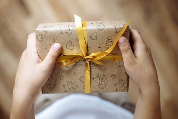 Closeup of a gift box in the hands of a child