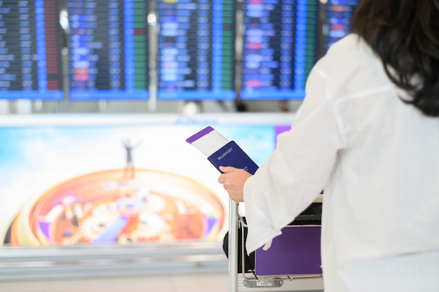 Closeup of girl holding passports and boarding pass at airport