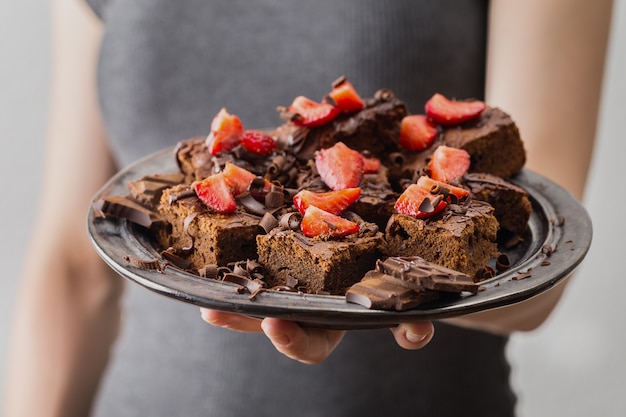 Closeup of girl holding ready chocolate brownies