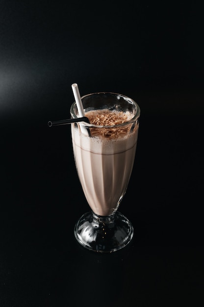 Closeup glas milkshake geïsoleerd op zwarte ondergrond