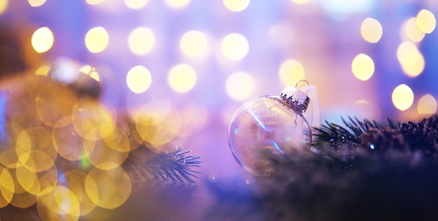 Closeup of glass Christmas ball on abstract light background.