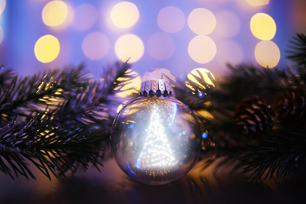 抽象的な光の背景にガラスのクリスマスボールのクローズアップ。
