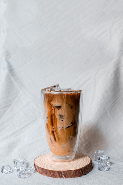 Closeup glass of iced coffee with milk on the table