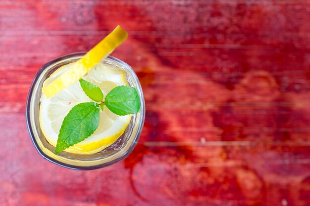 Closeup glass of lemonade on red tabletop