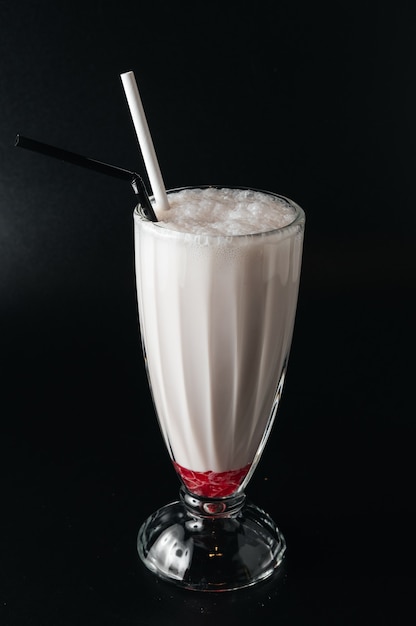 Closeup glass of milk shake isolated on black surface