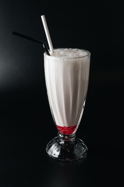 Closeup glass of milk shake isolated on black surface