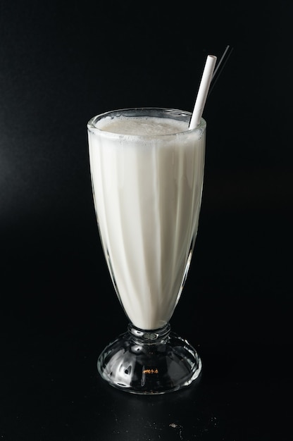 Closeup glass of milk shake isolated on black surface