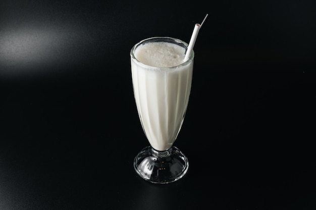 Closeup glass of milk shake isolated on black surface