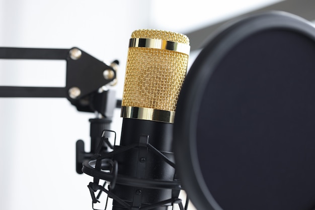 Closeup of golden microphone in recording studio