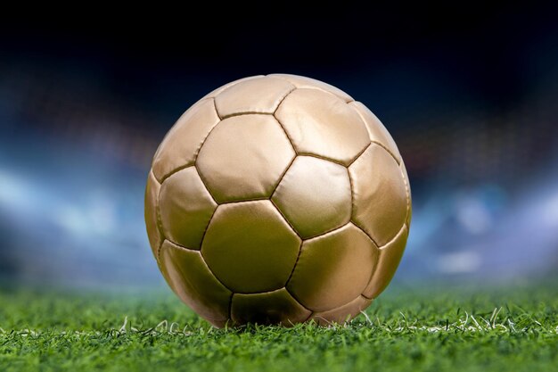 Closeup golden soccer ball and stadium with fans the night