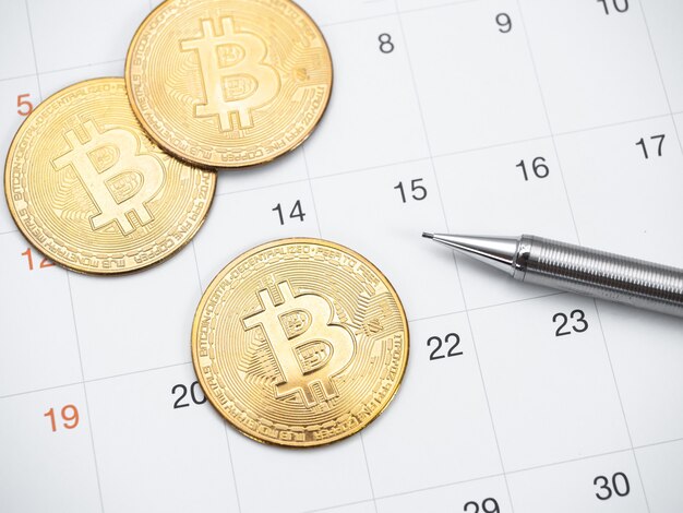 Closeup gouden bitcoin en pen op kalender