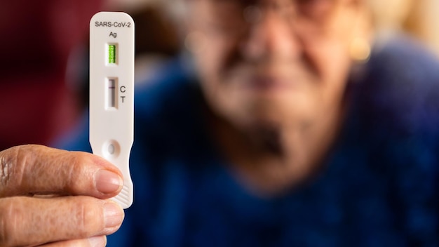 Photo closeup grandma hand holding a buffer dropper for seft detection of coronavirus