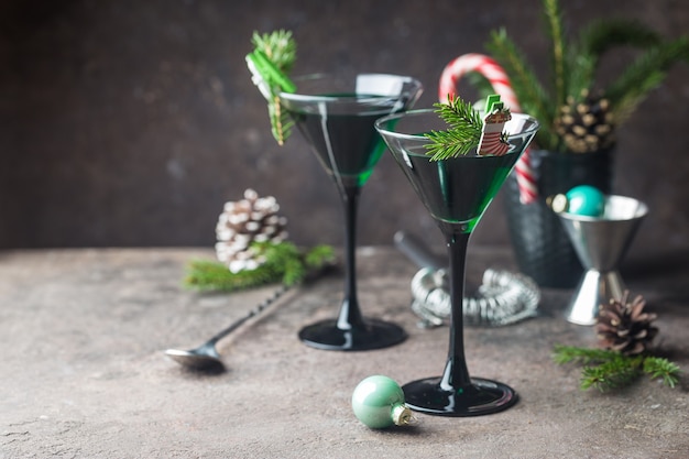 Closeup of green cocktails in martini glasses with mint leaves over gray