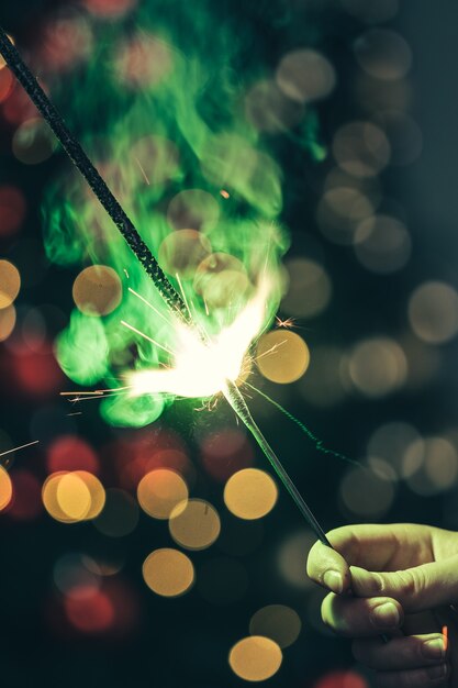 Primo piano dello sparkler di festa verde nel buio