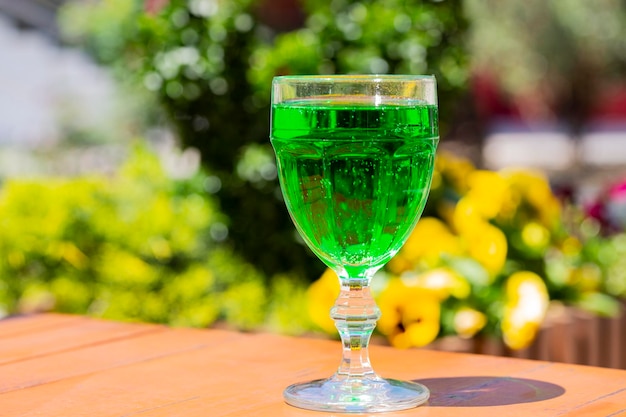 Closeup Green lemonade Tarragon in a glass glass on a blurry background Green drink from healthy herbs Tarragon