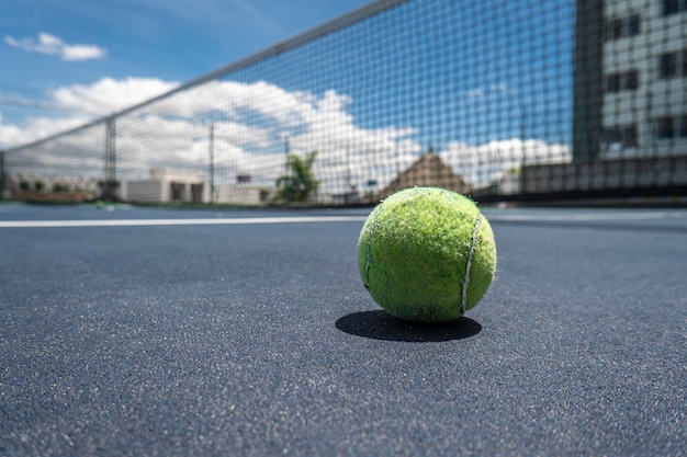 Closeup of green tennis ball and court in the city