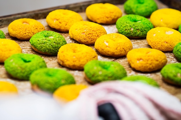 Closeup green and yellow ring eclairs on baking sheet