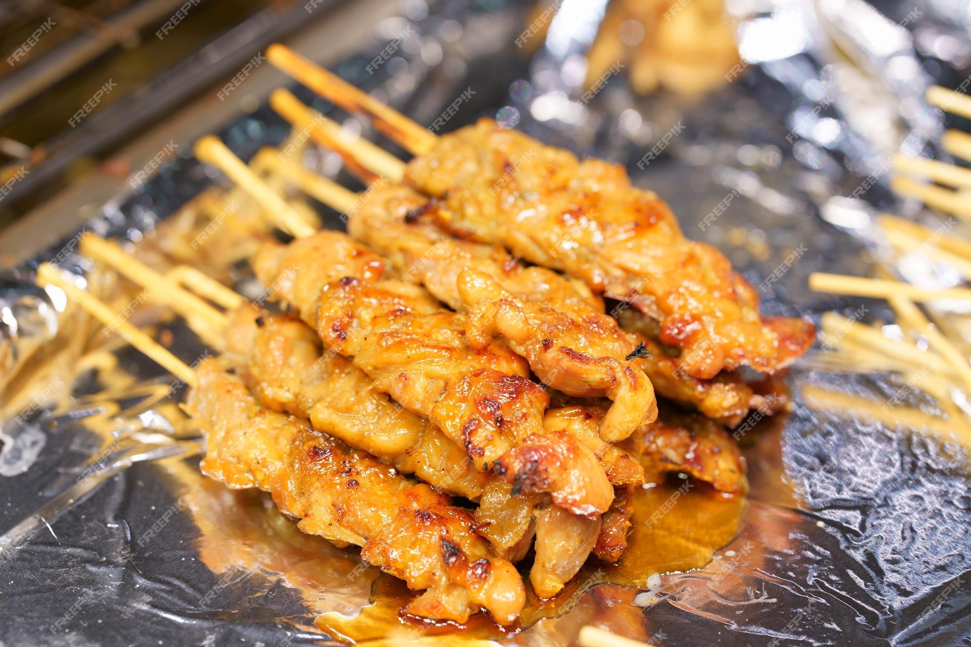 Premium Photo  Closeup of grilled skewered milk pork on stick thai street  food market