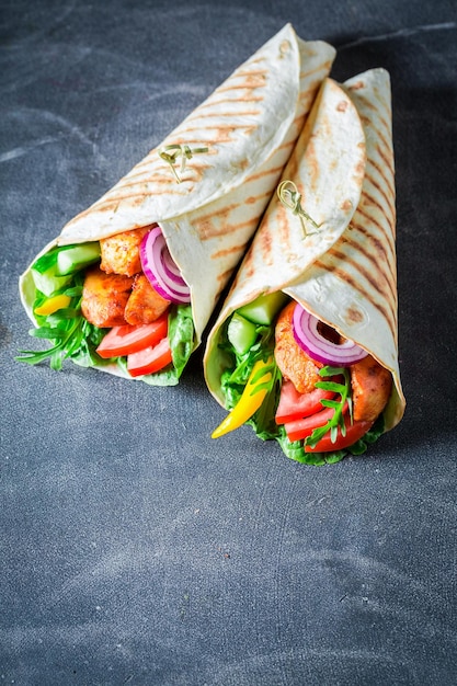 Closeup of grilled tortilla with tomatoes chicken and lettuce