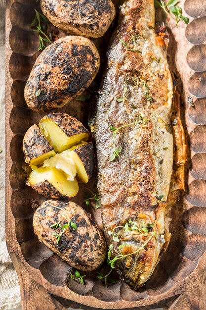 Closeup of grilled trout with potatoes herbs and butter