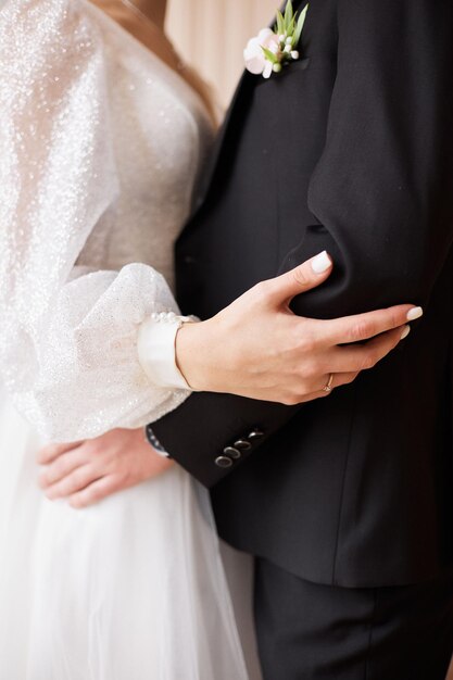 Photo closeup of the groom embracing the bride