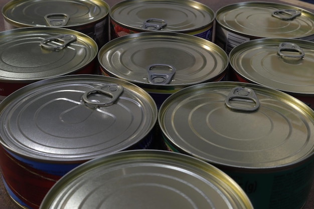 Closeup of a group of closed tin cans with a key to open them