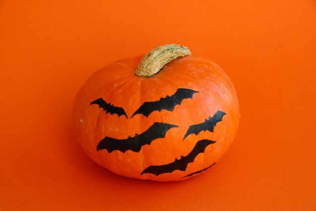 closeup Halloween pumpkin isolated on an orange background frontal