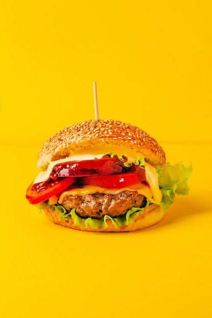 Foto un primo piano di un hamburger su uno sfondo giallo