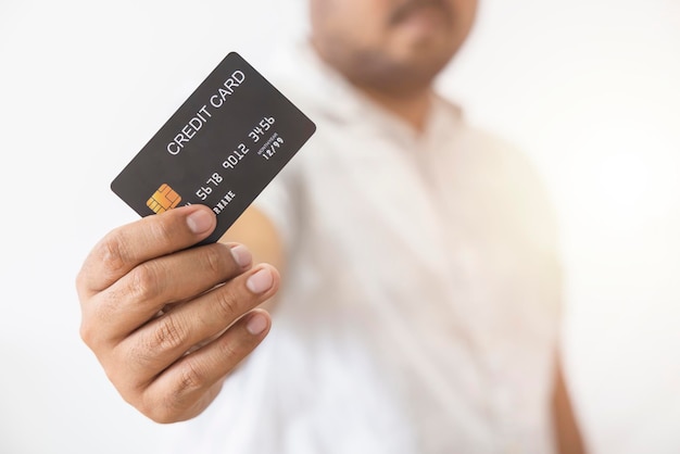 Closeup hand of Asian man holding black credit card in his hand isolated on white background Concept of trading social technology business