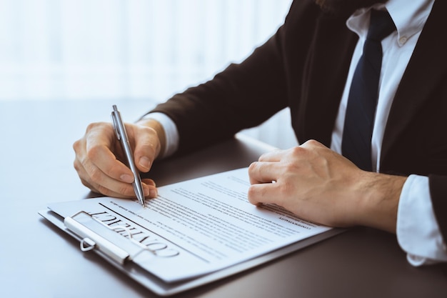 Closeup hand of businessman singing contract agreement paper Equilibrium